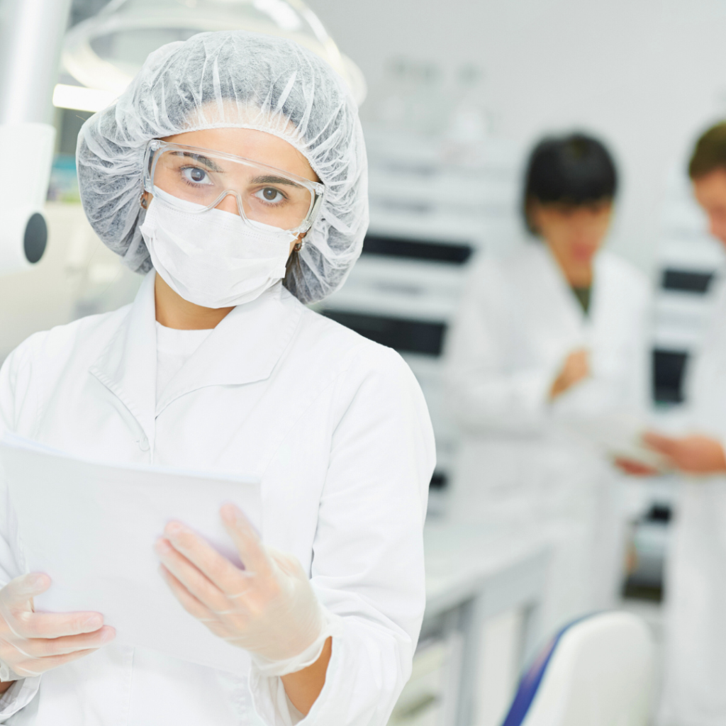 USP 797 cleanroom requirements followed by gowned lab personnel reviewing documentation