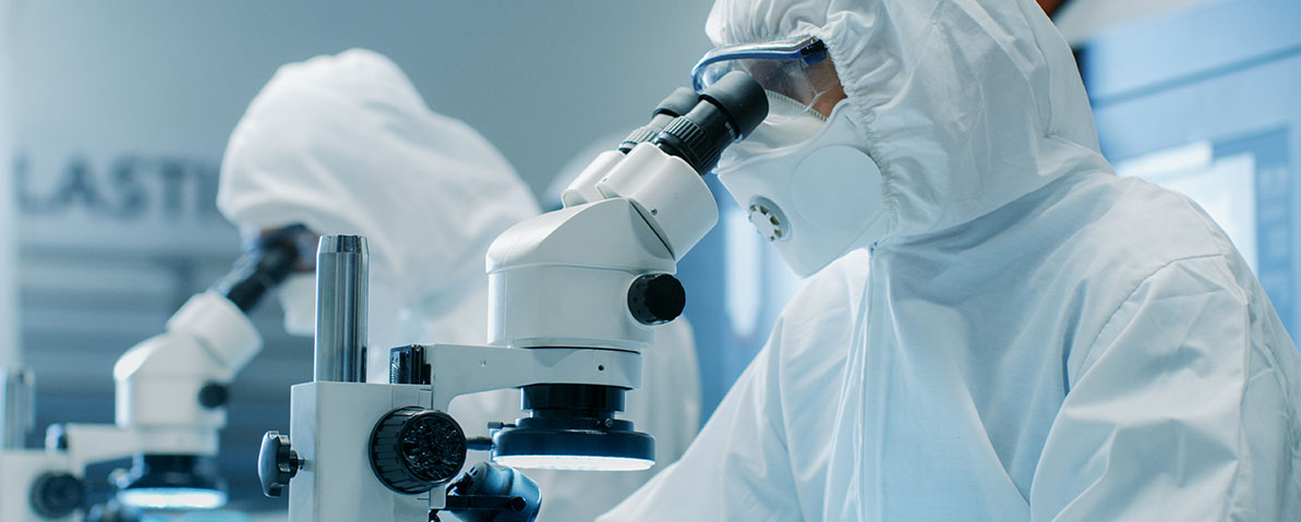 Air sampler certification — suited technicians using microscopes in cleanroom