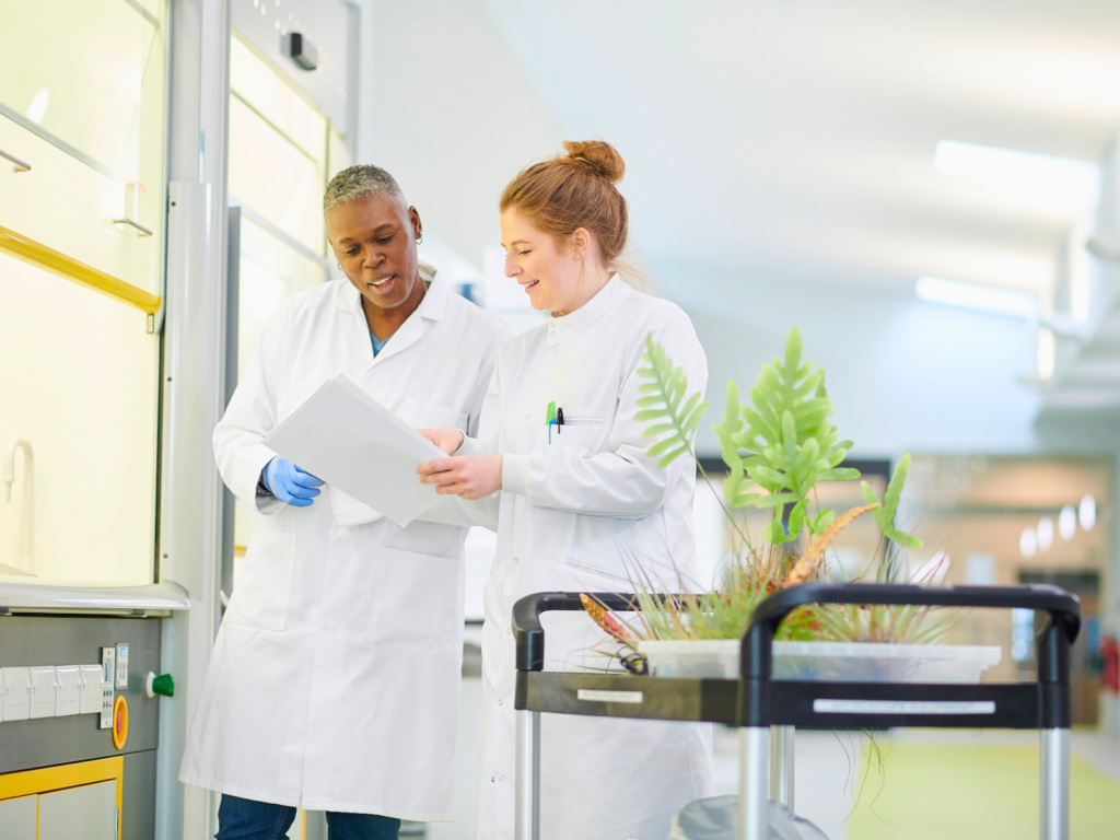 Air sampler certification — two lab scientists reviewing documents in research facility