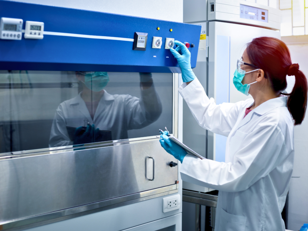 Fume hood service technician adjusting controls in a laboratory setting